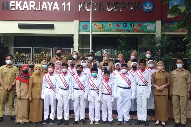 UPACARA : Seusai menjadi Irup, Lurah Abadijaya, Sodik Murdiono foto bersama Kepala sekolah, dewan guru dan pasukan upacara bendera SDN Mekarjaya 11, Senin pagi (10/10). ANDIKA EKA/RADAR DEPOK
