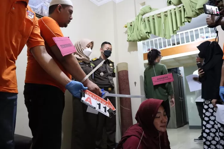 REKONSTRUKSI : Pelaku pembunuhan anak kandung dan penganiayaan istri, RNA ketika memperagakan dirinya saat membacok istrinya dalam adegan ke 11 di kediamannya, Klaster Jatijajar, Kecamatan Tapos Kota Depok, Kamis (24/11). GERARD SOEHARLY/RADAR DEPOK