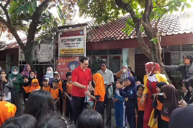 BERBAGI: Hariyanro Arbi bagi-bagi puluhan baju, sepatu, raket dan net untuk memberikan semangat kepada siswa-siswi SDN Pondok Cina 1 di Jalan Stasiun Pondok Cina, Kelurahan KemiriMuka, Kecamatan Beji, Kota Depok, Selasa (22/11). ASHLEY/RADAR DEPOK
