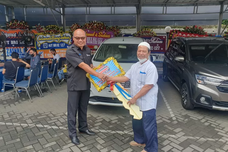 BERUNTUNG : Pemimpin Cabang BRI Depok, Wisnu Aji Wibowo menyerahkan secara langsung mobil Suzuki Ertiga kepada Samiyo, Nasabah BRI Unit Depok Timur yang memenangkan grandprize dalam Panen Hadiah Simpedes (PHS) Periode 1 Maret 2022- 31 Agustus 2022 Pelataran Parkir BRI Kanca Depok, Jalan Raya Margonda, Kelurahan Depok, Kecamatan Pancoranmas, Senin (19/12). Istimewa