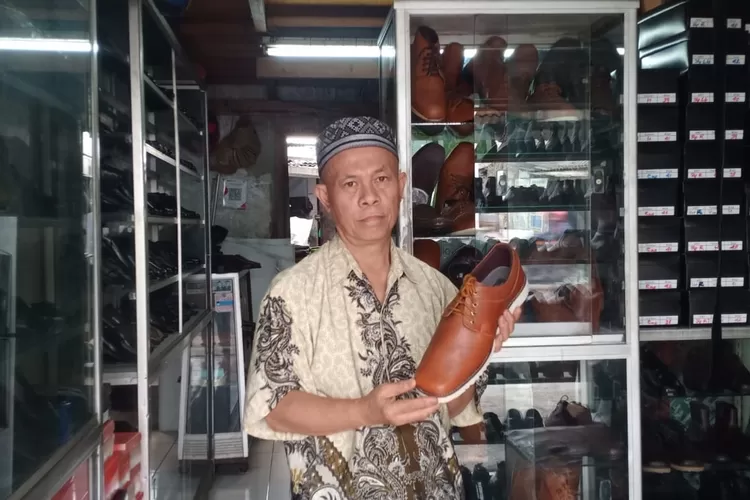 NEW HUNTERIA : Sang pemilik toko sepatu kulit asli, Muhammad Ahda, sedang memegang produk sepatunya yang berada di Jalan Siliwangi No7 Kota Depok, Rabu (30/11). AUDIE SALSABILA/RADAR DEPOK