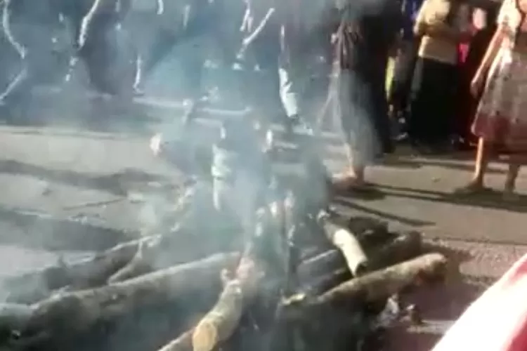 Ratusan warga Desa berkumpul di Jalinsum Desa Aek Libung Kecamatan Sayur Matinggi Kabupaten Tapsel, dengan menumbangkan pohon yang ada di pinggir jalan dan melakukan pembakaran ban bekas, diduga akibat pembagian BLT Dana Desa untuk warga kurang mampu dan ekonominya terdampak Covid-19 yang dibagikan pihak aparat Desa dinilai kurang adil,menyebabkan arus lalu lintas dua arah macet total, Kamis (25/06/2020).(Foto : Realitasonline / Riswandy)