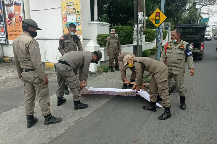 Satuan Polisi (Satpol) Pamong Praja (PP) Sumatera Utara (Sumut) dan Kota Medan melakukan penertiban reklame yang dipasang di pohon, tiang listrik dan tiang telepon di berbagai kawasan di Kota Medan, Kamis (4/3).