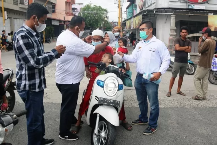 Ketua PWI Sibolga-Tapteng, Jason Gultom didampingi Sekretaris Preddy Situmorang dan Wakil Ketua Haris Sikumbang, membagikan masker dan takjil kepada pengendara. (Ist)