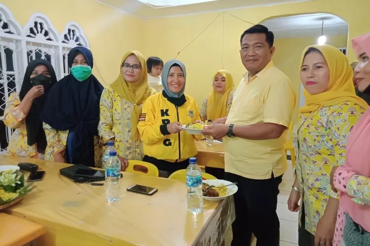 Ketua PD KPPG Paluta Hj Ipa Riwaty Siregar memberikan potongan nasi tumpeng kepada sekretaris Partai Golkar Paluta Mula Rotua Siregar pada tasyakuran HUT KPPG Ke-19, Minggu (23/05).(REALITAS/AKHIR S RAMBE)