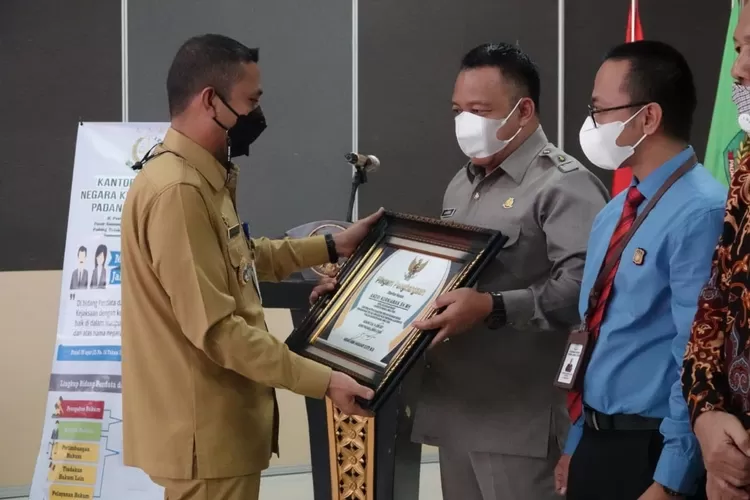 Bupati Paluta Andar Amin Harahap SSTP MSi saat menyerahkan piagam penghargaan kepada Kajari Paluta Andri Kurniawan SH MH, Selasa (15/06).(REALITAS/AKHIR S RAMBE)