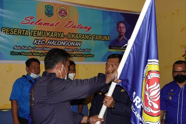 Ketua Karang Taruna Kabupaten Paluta Mula Rotua Siregar menyerahkan bendera pataka kepada Dedi Harahap SH sebagai ketua Karang Taruna kecamatan Halongonan, Selasa (22/06).