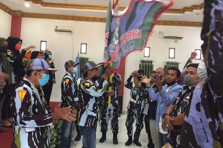 Ketua DPD IPK Paluta Syahrul Fahmi Siregar menyerahkan bendera pataka kepada ketua PAC IPK Padang Bolak Muhammad Adil Siregar, Minggu (22/08).(REALITAS/AKHIR S RAMBE)