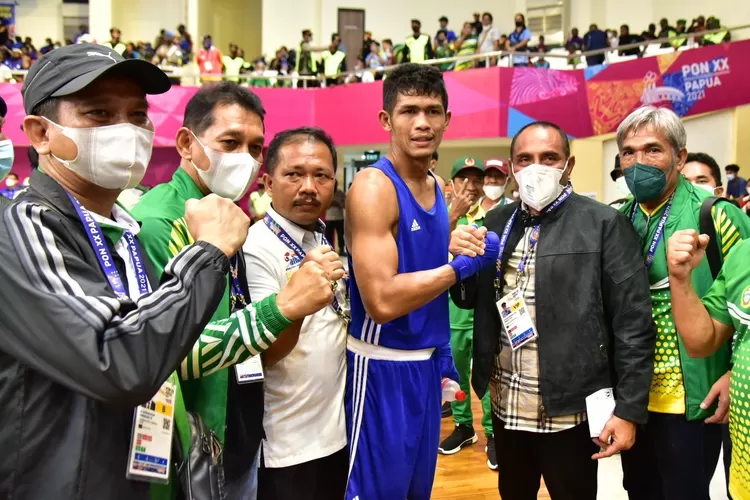 Gubernur Sumut Edy Rahmayadi menyaksikan final pertandingan cabang olahraga tinju kelas welter putra 64-69 Kg pada PON XX Papua 2021 antara Sarohatua Lumbantobing (Biru) asal Sumut melawan Saputra Samada (Merah) asal Nusa Tenggara Barat di GOR Cendrawasih Jalan Ardipura 2, Kota Jayapura, Papua, Rabu (13/10/2021) malam. Sarohatua Lumbantobing berhasil menang dan menyumbang  medali emas untuk Sumut. 