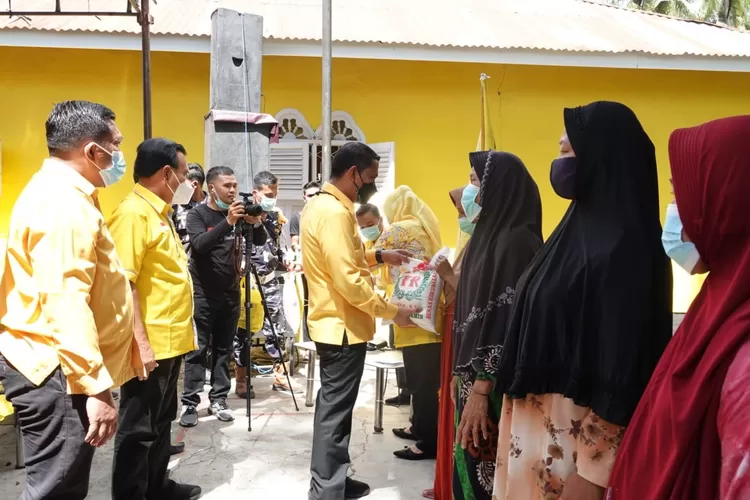 Ketua DPD II Partai Golkar Paluta Andar Amin Harahap SSTP MSi menyerahkan bantuan sembako kepada warga dalam rangka HUT Partai Golkar ke 57, Sabtu (16/10). (AKHIR S RAMBE)