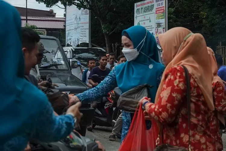 Ketua TP PKK Paluta Ny Ade Aan Rostiani Andar Harahap bersama pengurus PKK dan DWP Paluta bagikan takjil gratis di depan Mesjid Raya Paluta, Selasa (19/04).(REALITAS)