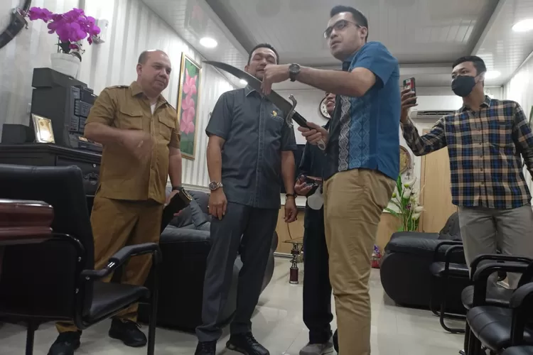 Afif Abdillah saat menjajal ketajaman koleksi pedang kuno, barang antik milik pribadi Kadis Kebudayaan. (Ist)