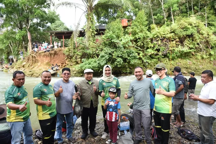 Bupati Tapsel H Dolly Pasaribu bersama Ketua TP. PKK Kabupaten Tapsel Ny. Rosalina Dolly Pasaribu dan Kadis Perikanan Tapsel, Sofyan Adil, usaibmembagikan kartu KUSUKA kepada masyarakat pelaku usaha perikanan, saat membuka festival pancing lubuk larangan Parsariran, di Desa Sipenggeng, Kecamatan Batang Toru, Kabupaten Tapsel, Minggu (20/11/2022).(Foto ; Realitasonline/Riswandy)