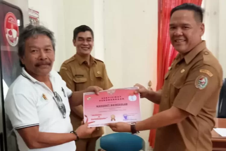 Kadis Kominfo Taput Hendrik Taruna Surbakti serahkan piagam penghargaan kepada ketua panitia lomba karya tulis jurnalistik tahun 2022. (realitasonline/MN)