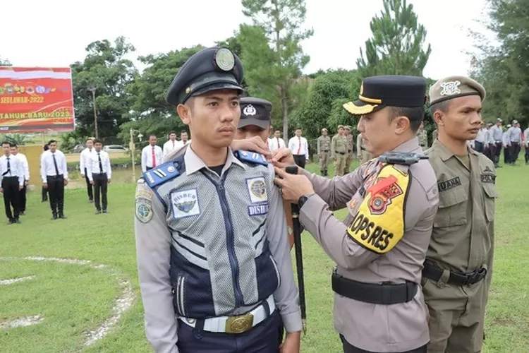Foto: Kapolres Abdya, AKBP Dhani Catra Nugraha menyematkan pita kepada perwakilan personel dalam apel gelar pasukan operasi Lilin 2022 yang berlangsug di halaman Mapolres setempat, Kamis (22/12). (Realitasonline.id - ZAL)