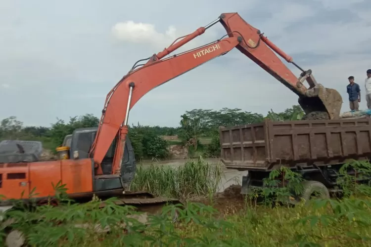Pengorekan di bantaran Sungai Ular menggunakan beko