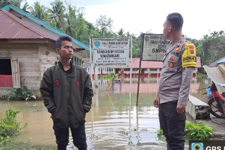 Personil Bhabinkamtibmas Polres Tapsel memantau permukiman warga yang terendam banjir di Desa Simataniari Kecamatan Angkola Sangkunur Kabupaten Tapsel. (Foto : Realitasonline/Riswandy)