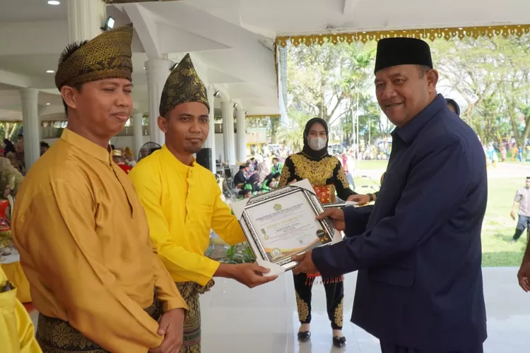 Plt Bupati Langkat Syahafandin saat menyerahkan satya lencana kepada ASN Kementerian Agama RI pada peringatan HAB ke-77