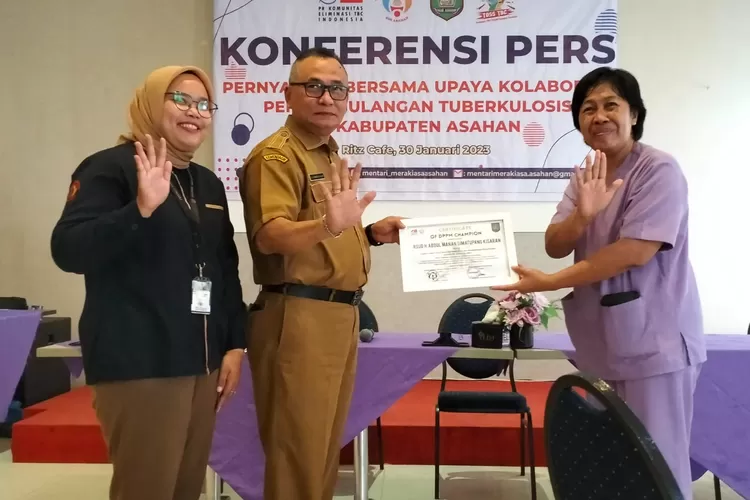 Kadis Kesehatan dr. Nanang Fitra Aulia, didampingi Ketua Yayasan Mentari Meraki Asa Asahan, Nurul Huda, saat memberikan piagam penghargaan kepada dr. Nini Deritana Sp. P., dalam acara konferensi pers. (Ist)