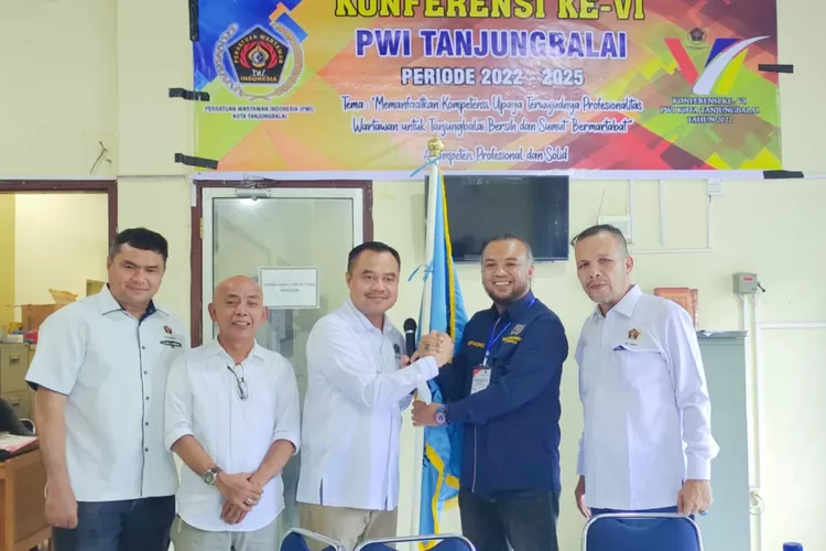 Ketua PWI Sumut Farianda Putra Sinik menyerahkan bendera petaka PWI Tanjung Balai kepada Ridwan Marpaung terpilih menjadi ketua