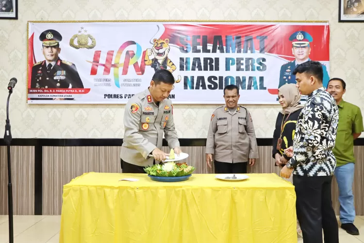 Kapolres Padang Sidempuan memotong tumpeng   syukuran HPN 2023  bersama para insan perss yang tergabung pada 'Pojka Jurnalis Polres Padang Sidempuan.(Foto : Realitasonline/Riswandy)