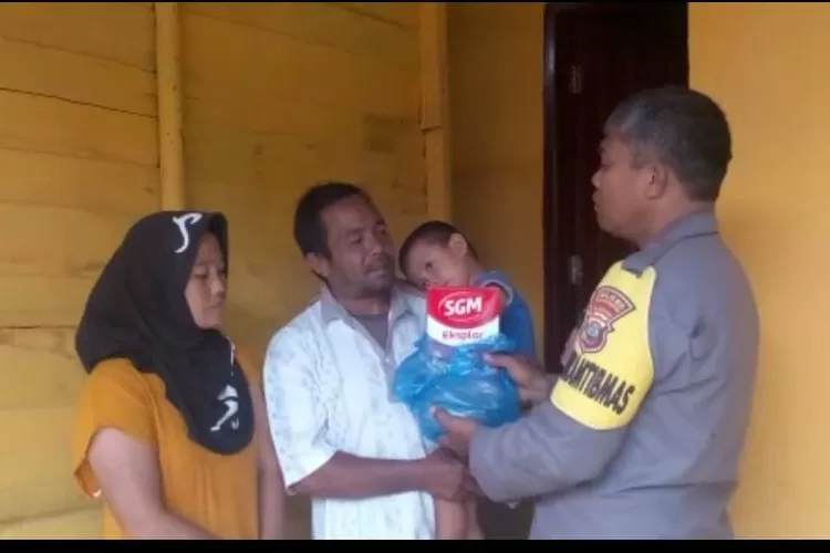 Personil Bhabinkamtibmas Polsek Batunadua Polres Padang Sidempuan, Aiptu Agus Salim Pane membagikan susu kepada Balita di Kelurahan Silandit Lingkungan III, Kecamatan Padang Sidempuan Selatan, Kota Padang Sidempuan, Senin (27/2/2023).(Foto : Realitasonline / Riswandy)