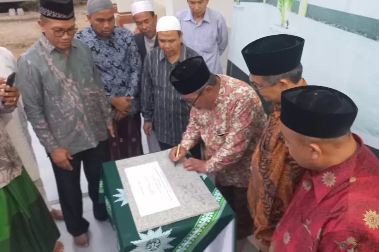Pimpinan Wilayah Muhammadiyah Aceh Dr. Muharrir sedang membubuhi tanda tangan pada berita acara penyerahan Tempat Wudhu Masjid Taqwa Muhammadiyah Kecamatan Juli. (Ist)