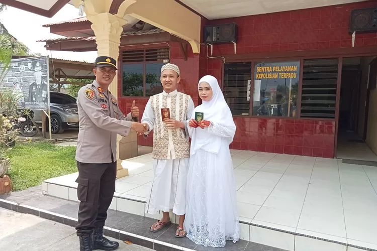 Kapolsek Indrapura AKP Jonni H. Damanik SH MH menyalami pasangan pengantin yang baru menikah. (Photo:Realitasonline/H.Guntur Sinaga)