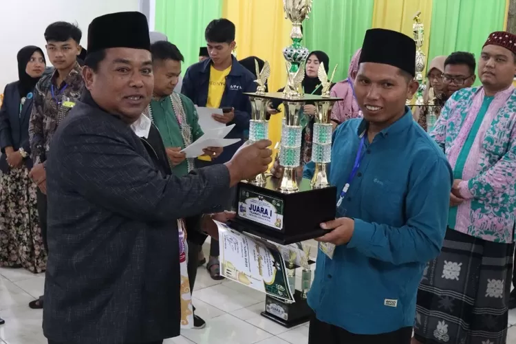 Ketua Panitia saat menyerahkan tropi sebagai juara umum kepada salah seorang kontingen dari Kecamatan Berastagi. (realitasonline/ist)