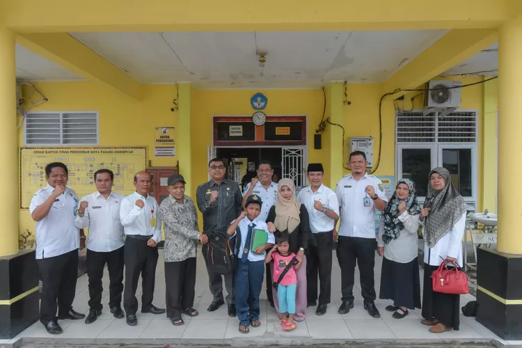 Kadisdik Padang sidempuan M Luthfy Siregar foto bersama Fitrah Azhari salah seorang anak putus sekolah menerima bantuan dari Walikota 