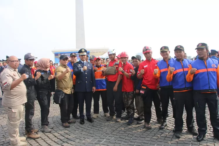 Gubernur DKI Anies Baswedan berfose bersama petugas  Damkar  di Monas, Jakarta Pusat, Selasa (17/9/2019).