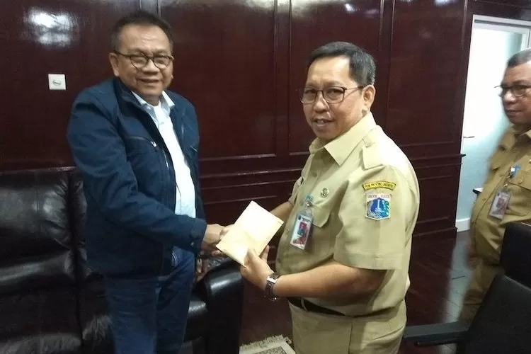 Wakil Ketua DPRD DKI M Taufik (kirim) menyerahkan  uang bantuan kepada Sekwan M Yuliandi untuk kemudian diserahkan kepada korban banjir, Senin (6/1/2020).
