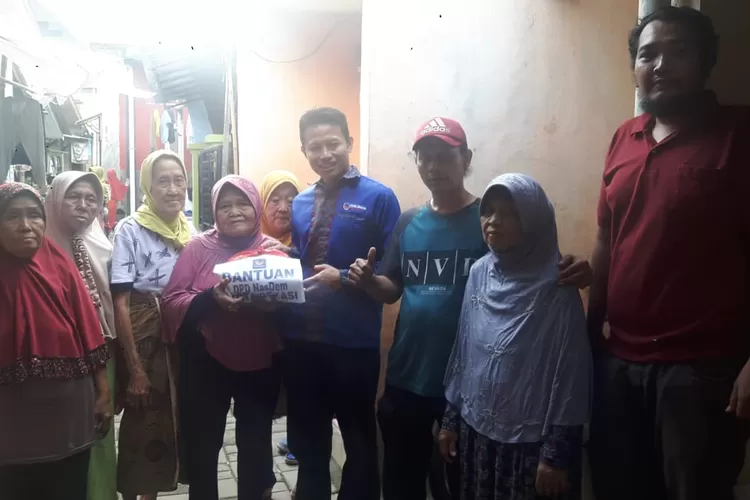 Sekjen DPD Partai Nas-Dem Kota Bekasi Aji Ali Sabana saat menyalurkan  bantuan bagi warga terdampak banjir. (Foto: Dok. Partai Nas-Dem).