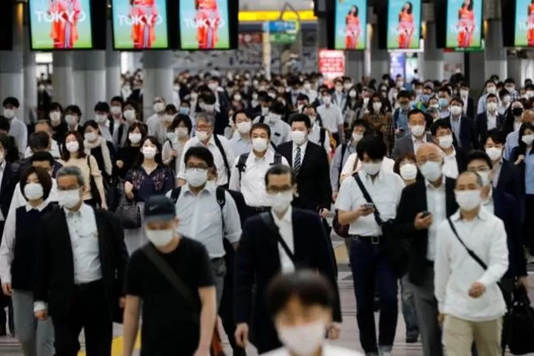 Orang-orang berjalan saat jam sibuk pada hari pertama setelah pemerintah Jepang mengangkat status keadaan darurat di Tokyo, Jepang, (26/5/2020).