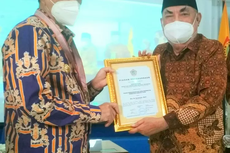  Ketua Umum PWRI Prof Dr Haryono Suyono (kanan)  menyampaikan tanda Kehormatan Wredatama Nugraha Utama pada Gubernur Riau Drs H Syamsuar MSi (kiri).(foto,ones)