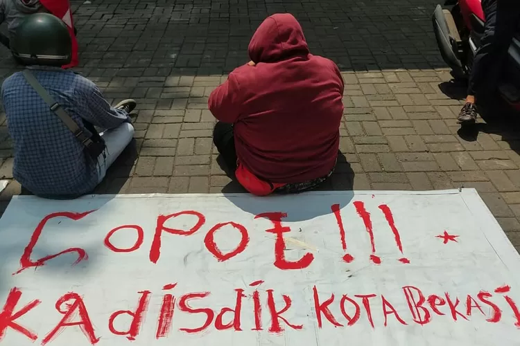 Sepanduk tetuliskan Copot Kadisdik Kota Bekasi saat tuntutan aksi damai aktivis GMNI Bekasi di Kantor Disdik Kota Bekasi pada Rabu (8/8/2021). (FOTO: Ist).