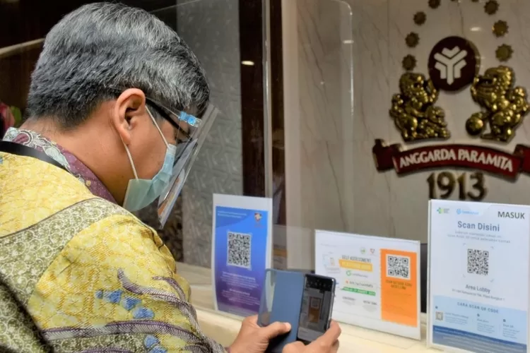 Plt. Putu Juli Ardika mempraktikkan penggunaan aplikasi PeduliLindungi di PT HM. Sampoerna, Rungkut, Surabaya