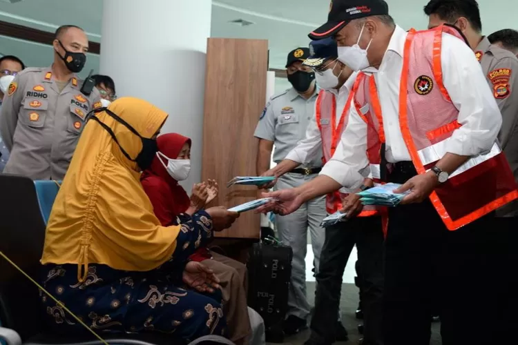 Menko PMK Muhadjir Effendy (kanan) bagikan masker, pada penumpang di pelabuhan penyeberangan.(foto,ist)