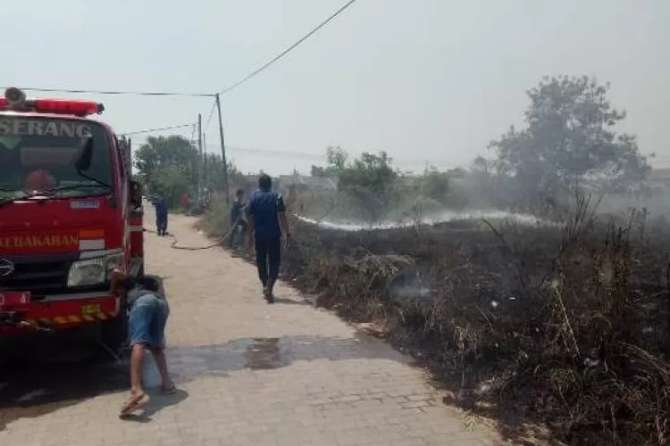 Petugas Damkar Kota Serang saat memdamkan Api yang membakar rumpul Ilalang di Perumahan Puri Serang Hijau. (foto:TOPmedia)