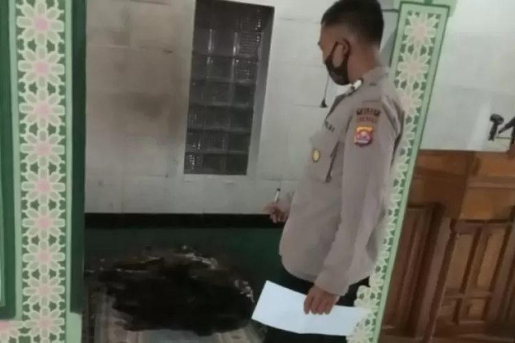 Petugas dari Kepolisian saat menunjukan sajadah yang telah dibakar oleh orang tak dikenal, di Masjid Jami Al-Falah, Kampung Petir, RT 003 RW 001, Desa Mekar Baru, Kecamatan Petir, Kabupaten Serang, Banten Senin (26/10/2020). (Foto:Istimewa)