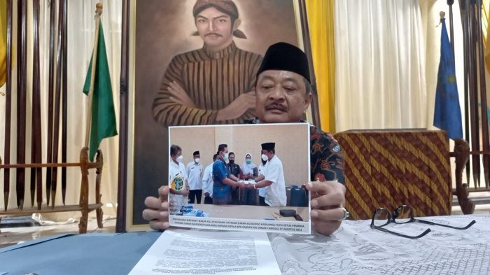 Ketua Pembina Yayasan Ahli Waris Sunan Kalidjogo, Raden Agus Supriyanto memperlihatkan foto saat menyerahkan 50 sertifikat wakaf kepada BPN. (suaramerdeka.com/Dok)
