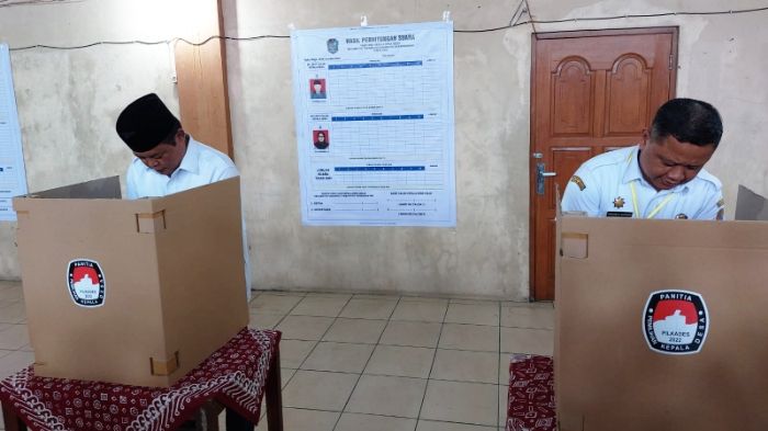 Bupati Karanganyar Juliyatmono (berpeci) saat memberikan hak suaranya dalam Pilkades Ngijo di Balai Desa Ngijo, Kecamatan Tasikmadu, Rabu (9/11/2022).  (SMSolo/Irfan Salafudin)