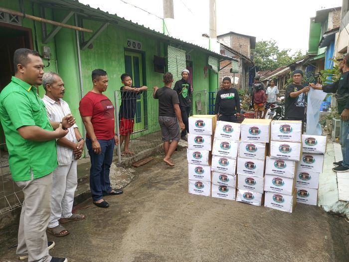 Ketua DPC PPP Karanganyar Imron Supomo menyerahkan bantuan sembako untuk warga terdampak luapan Bengawan Solo di Kampung Daleman, Dusun Banaran, Desa Ngringo, Kecamatan Jaten, Minggu (20/11).  (SMSolo/Irfan Salafudin )
