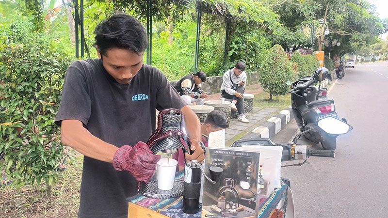 Aklis barista jalanan yang ada di komplek Perkantoran Setda Boyolali meracik kopi pesanan pelanggannya. (SMSolo/ Joko Murdowo)