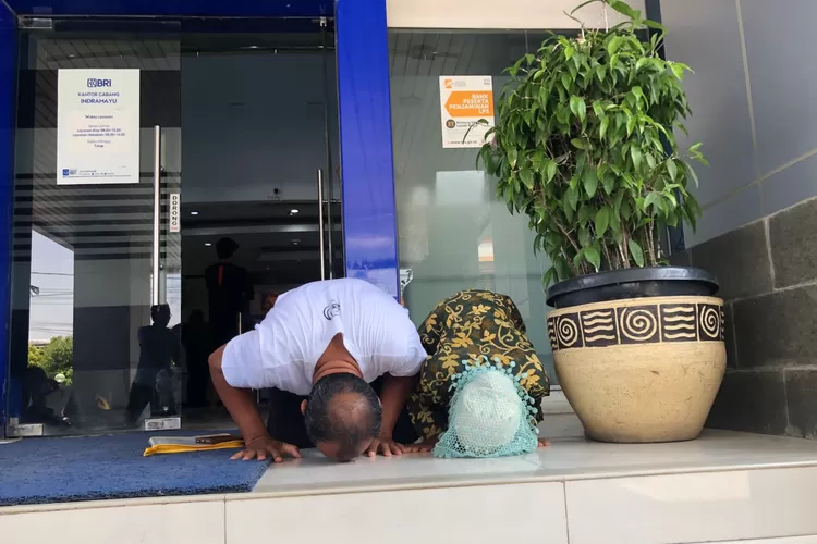 Dasuki dan ibunya, Sutinih sujud syukur setelah tabungannya yang disimpan di Perumda BPR KRI, dinyatakan layak bayar dan dijamin oleh LPS.  (Foto: Dokumen LPS)