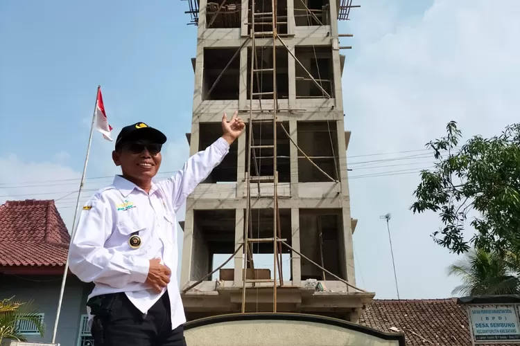 Kepala Desa Sembung Kecamatan Banyuputih Kabupaten Batang, Untung menunjukkan gedung baru delapan lantai yang masih proses pembangunan. Foto: Muslihun/kontributor Batang.