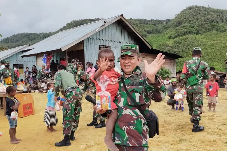 TUGAS : Mayor Inf&nbsp; P H B R Panjaitan sedang menggendong salah satu anak di Papua saat bertugas.  (DOKUMEN PRIBADI)