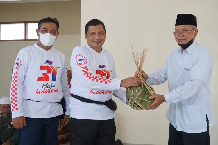 Perwakilan warga Kapanewon Girisubo memberikan hasil bumi kepada Head Regional Jateng-DIY, Marsudi (tengah) sebagai ucapan terima kasih telah singgah di desanya.  (Dok JNE Jogja)