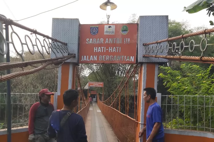 Masyarakat RW6, Kebon Duren, Kelurahan Kalimulya, Kecamatan Cilodong, Depok, melakukan perbaikan jembatan gantung atau biasa disebut jembatan oranye. (Atfal/Radar Depok)