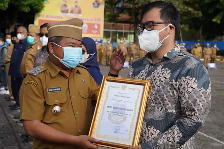 Bupati Garut Rudy Gunawan (kiri) memberikan penghargaan kepada pengusaha hotel dan restoran. (Agus Alvin/Gorajuara.com)